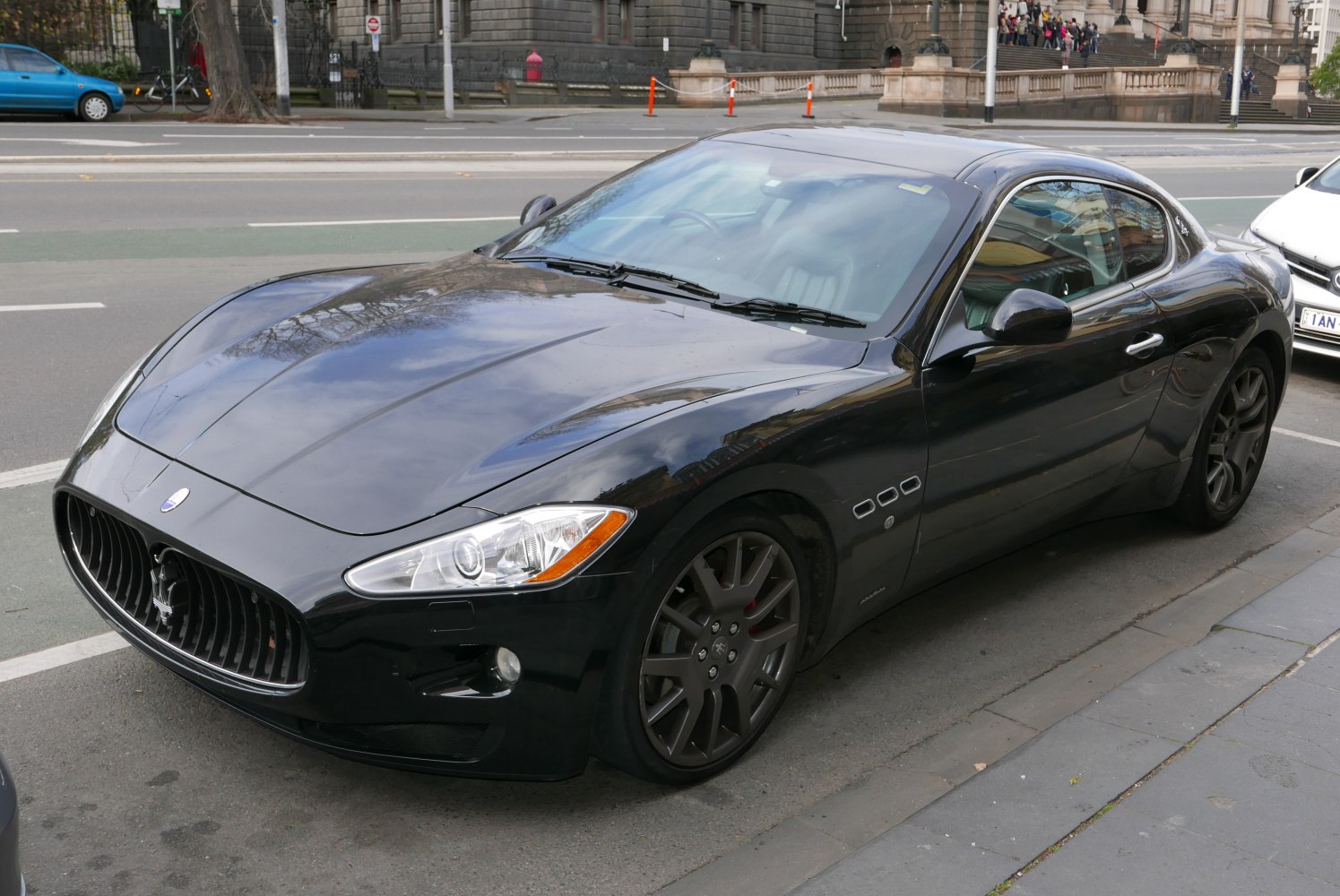 Glossy black sports coupe with prominent grille and unique headlights