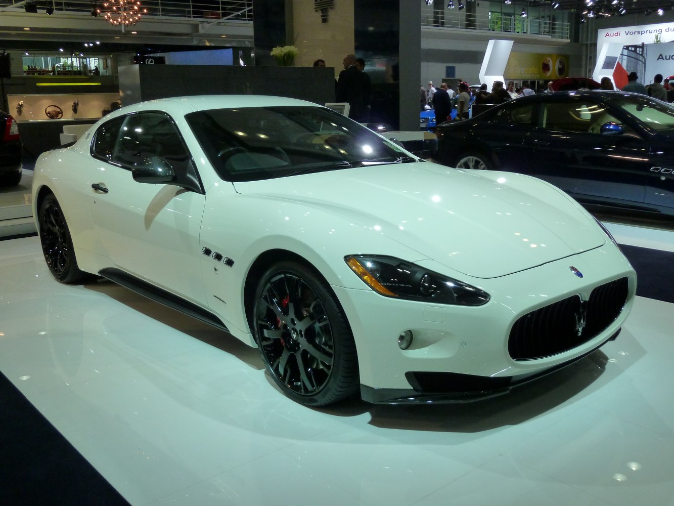 White luxury coupe with black alloy wheels and bold front grille