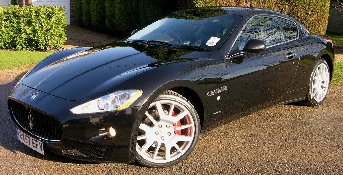 Front and side view of sleek coupe with white alloy wheels and red brake calipers