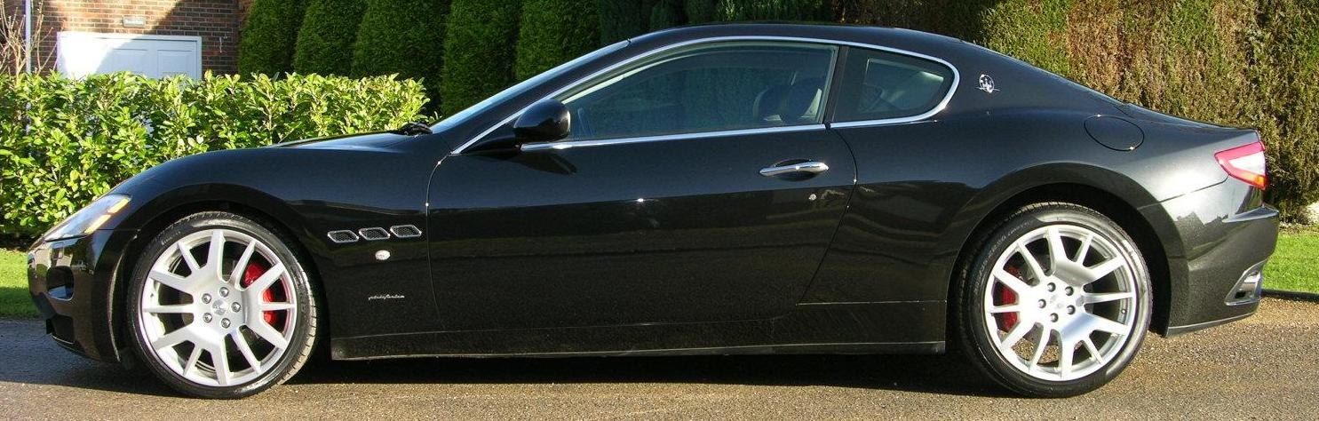 Sleek coupe side profile with large silver alloy wheels and red brake calipers