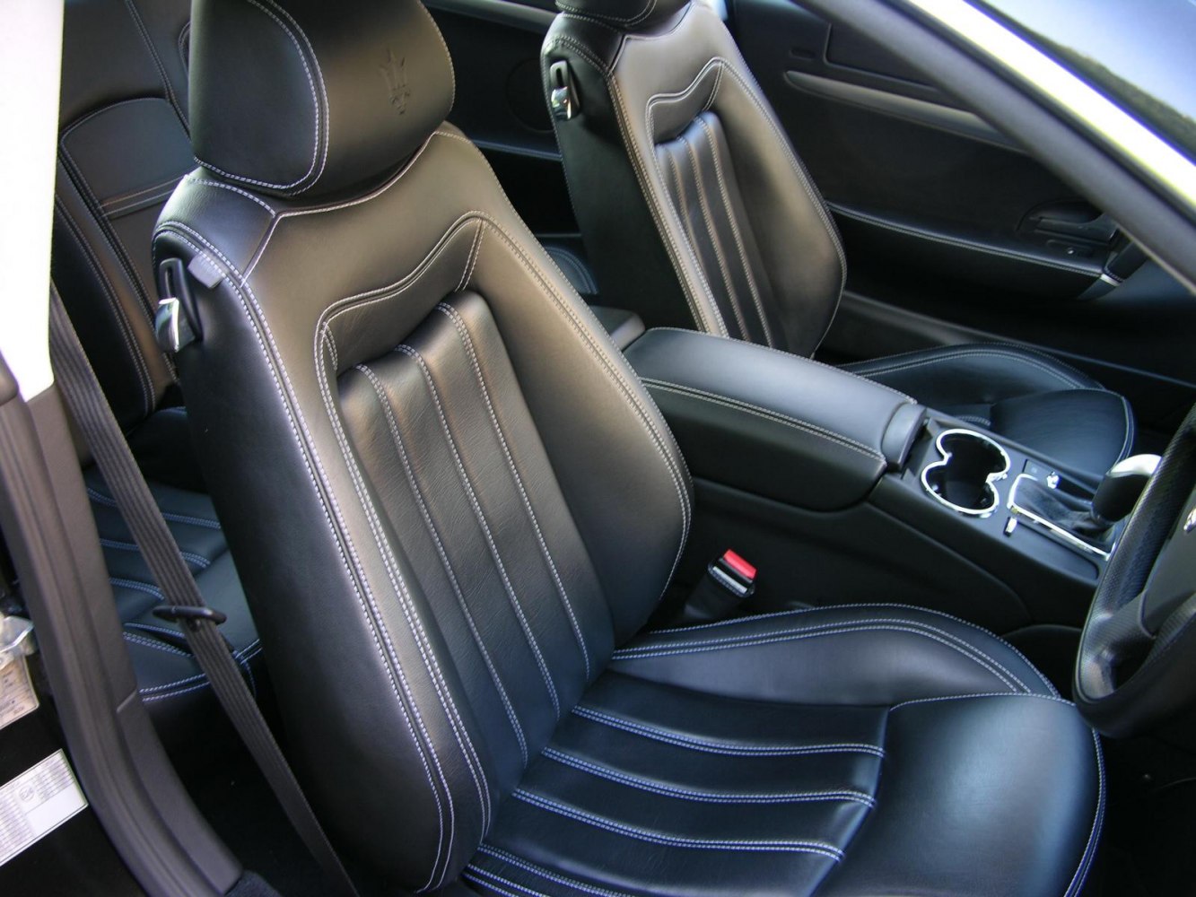 Black leather seats with white contrast stitching and sporty ergonomic design.