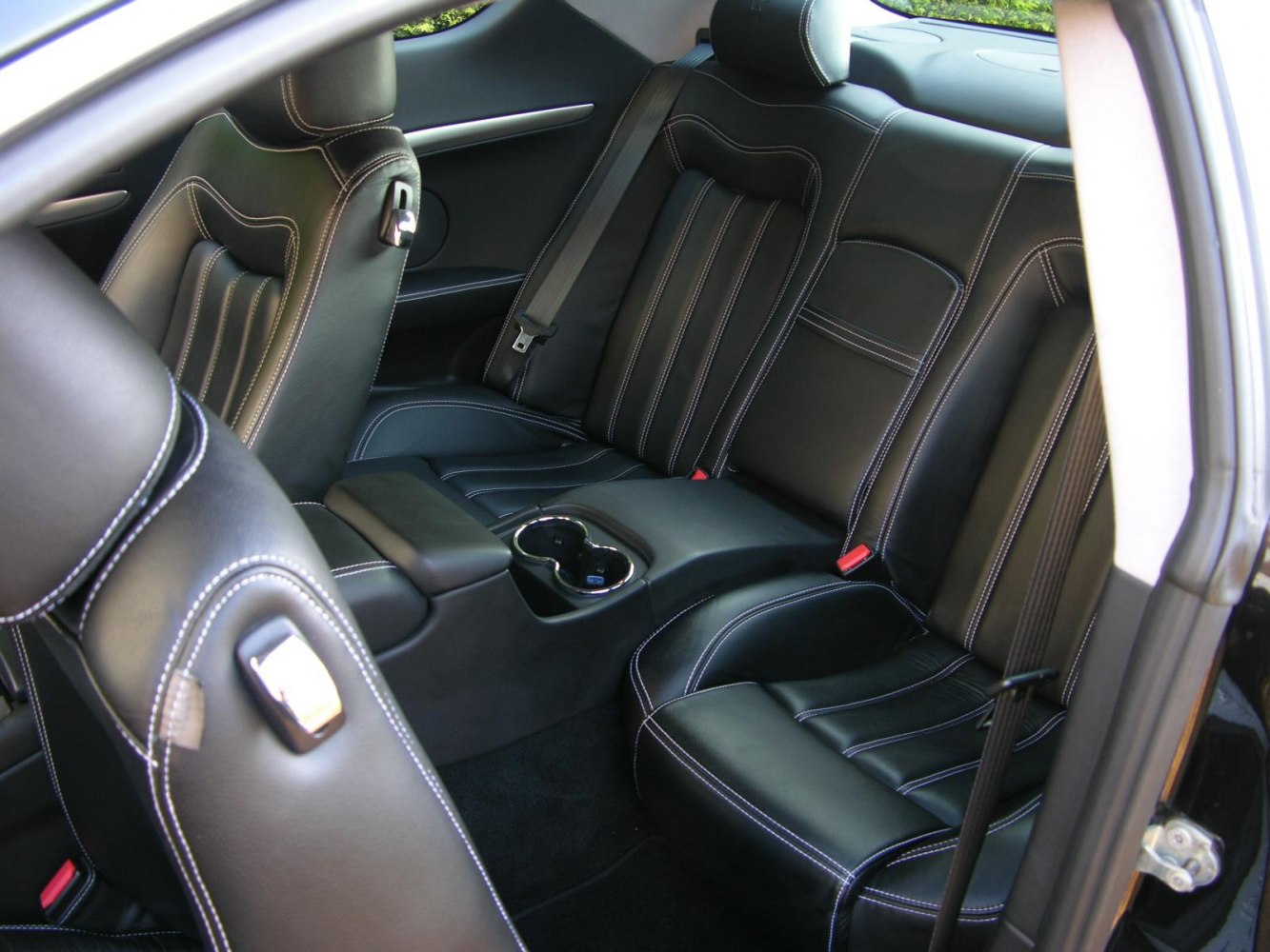 Black leather rear seats with white stitching and cup holders