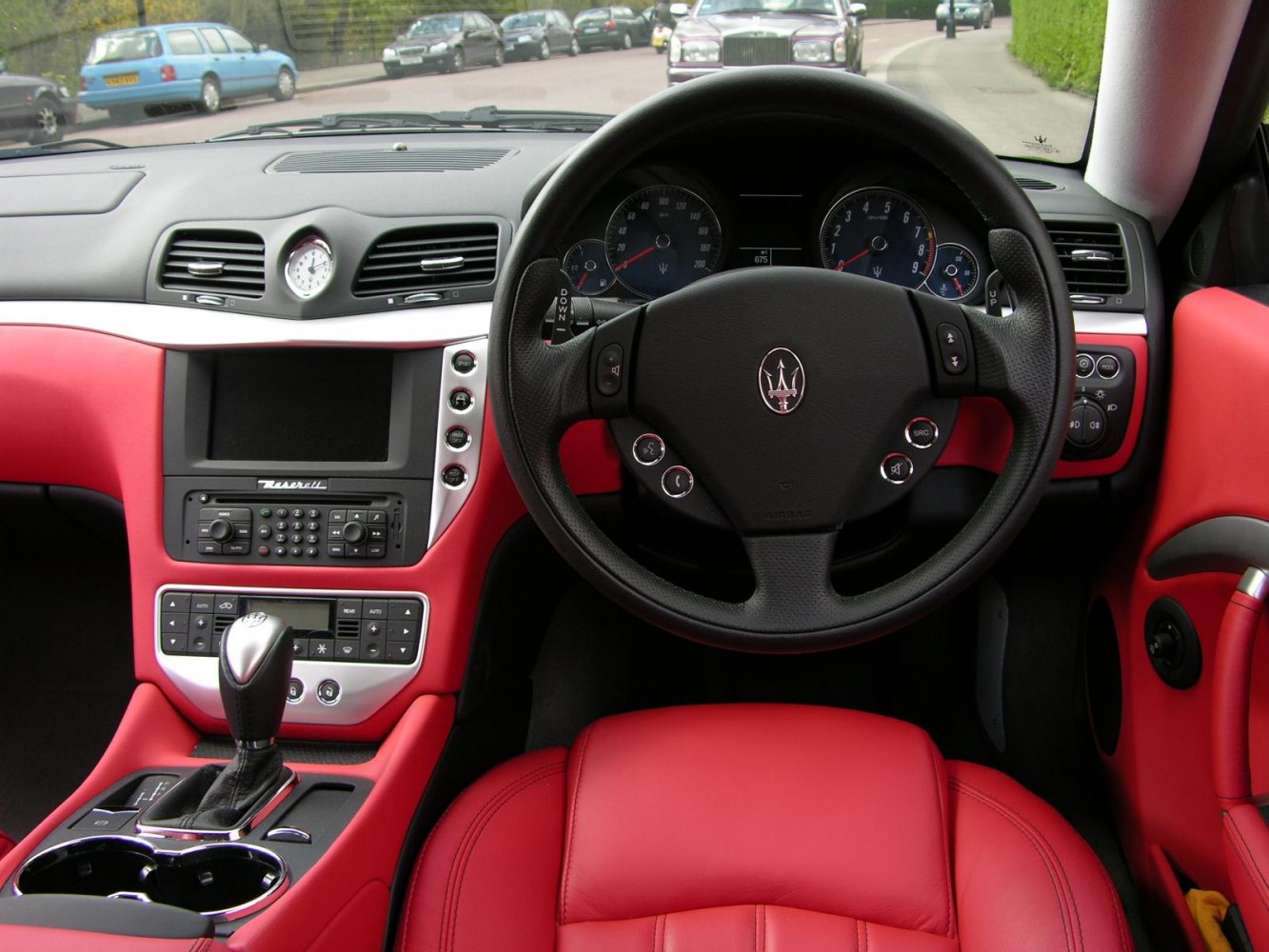 Sporty steering wheel and central dashboard with red leather upholstery