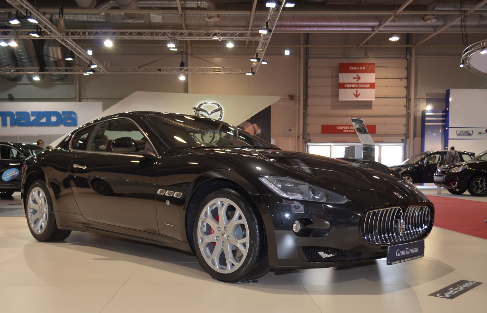 Front side view of a sleek car with chrome grille and alloy wheels