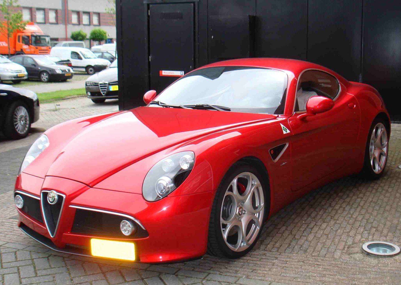 Front three-quarter view of a sleek sports coupe with aggressive headlights and alloy wheels.