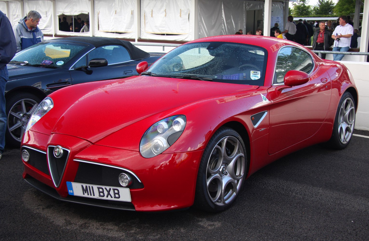Red sports coupe with distinctive headlights and alloy wheels