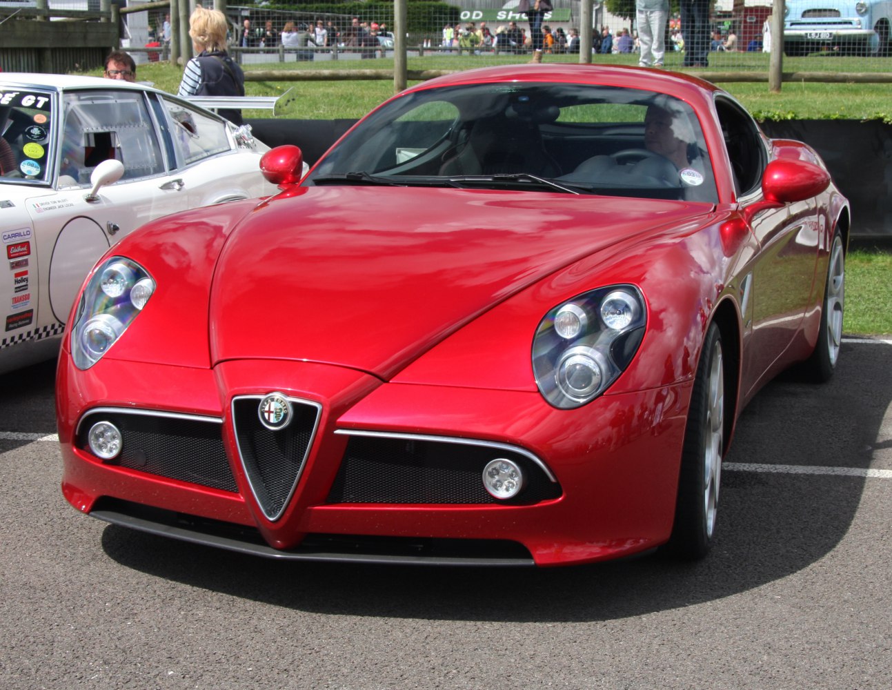 Red sports car front with distinctive grille and quad round headlights