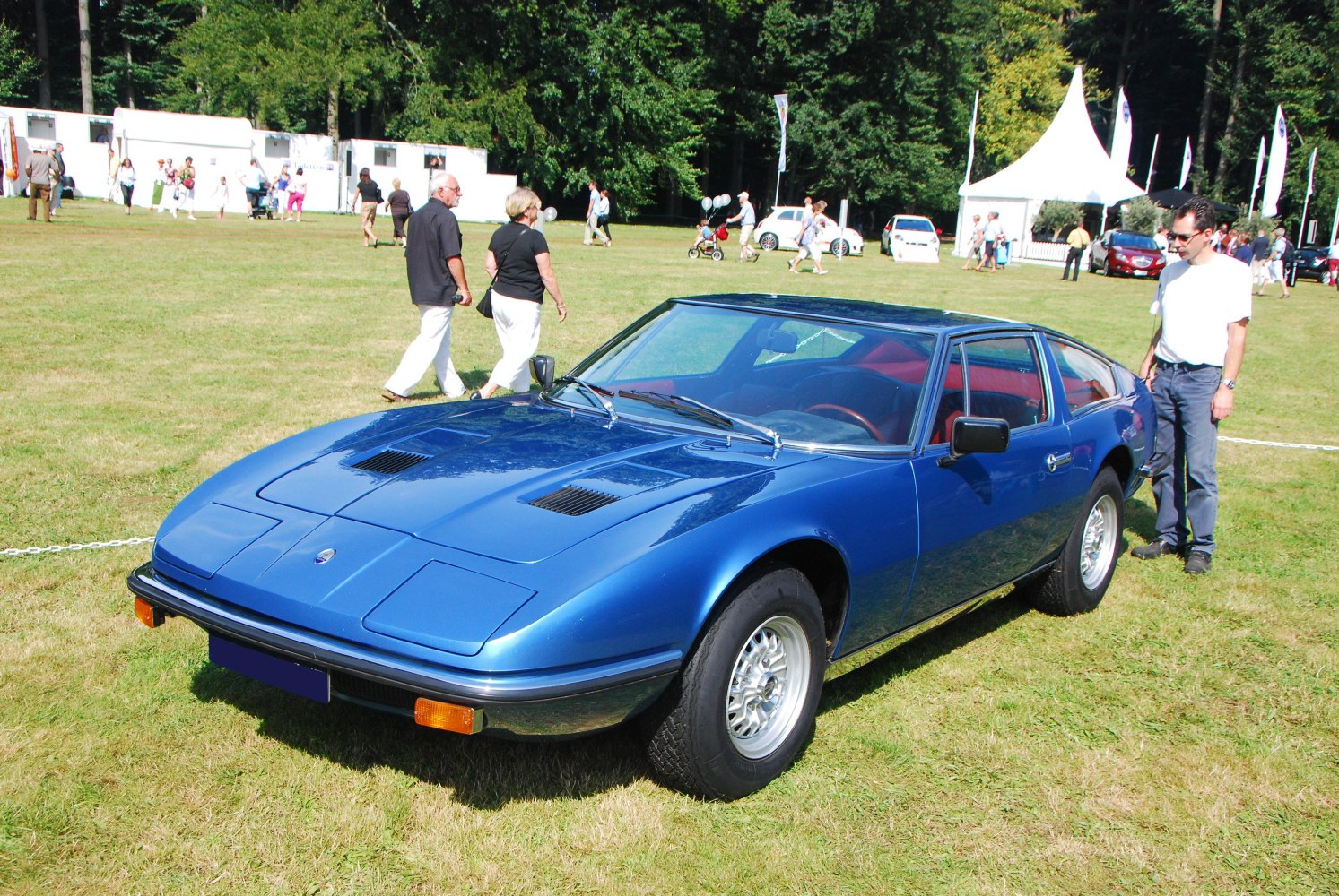 Blue vintage sports coupe with pop-up headlights and hood vents