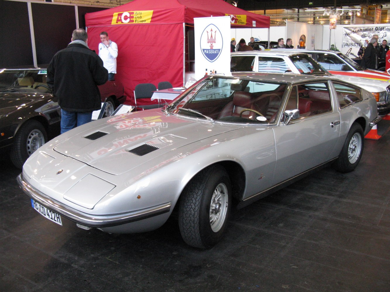 Front-side view of silver coupe with pop-up headlights and vintage styling