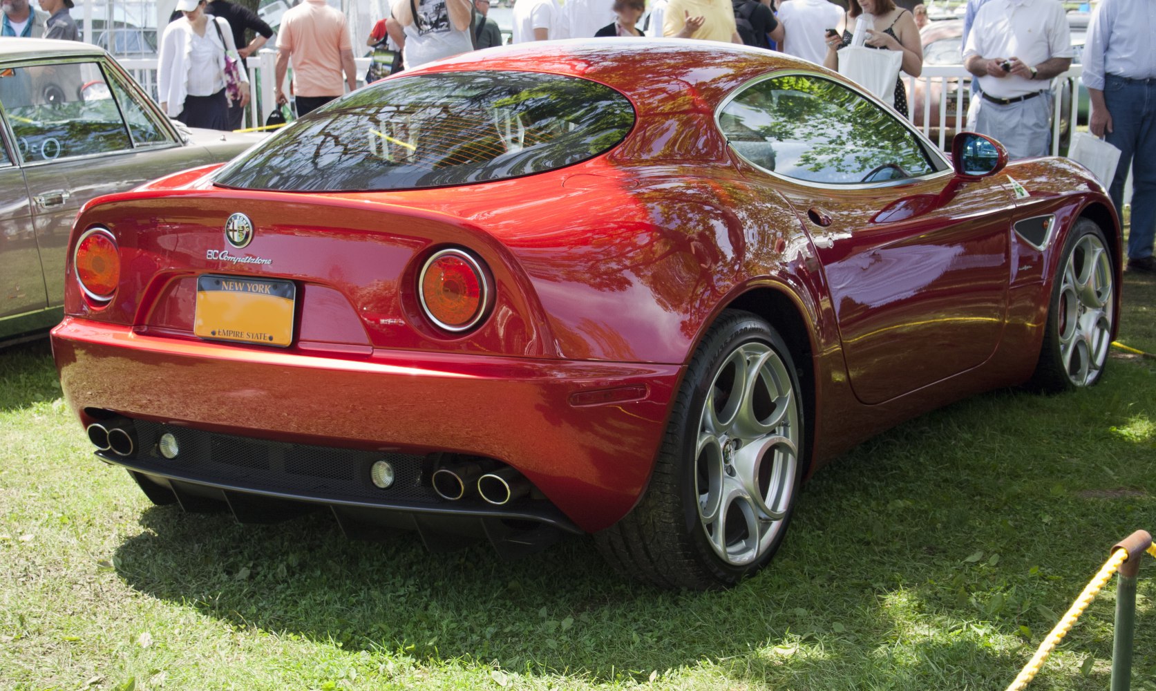 Red coupe rear design with dual circular tail lights and quad exhaust pipes