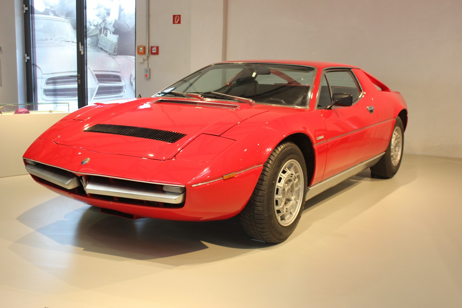 Red classic coupe with pop-up headlights and alloy wheels