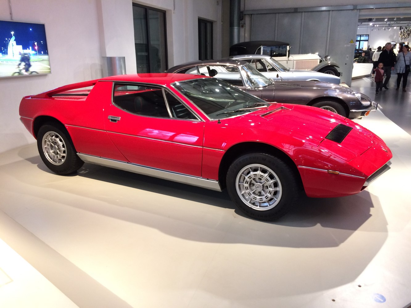 Red two-door coupe with mid-engine layout and classic alloy wheels