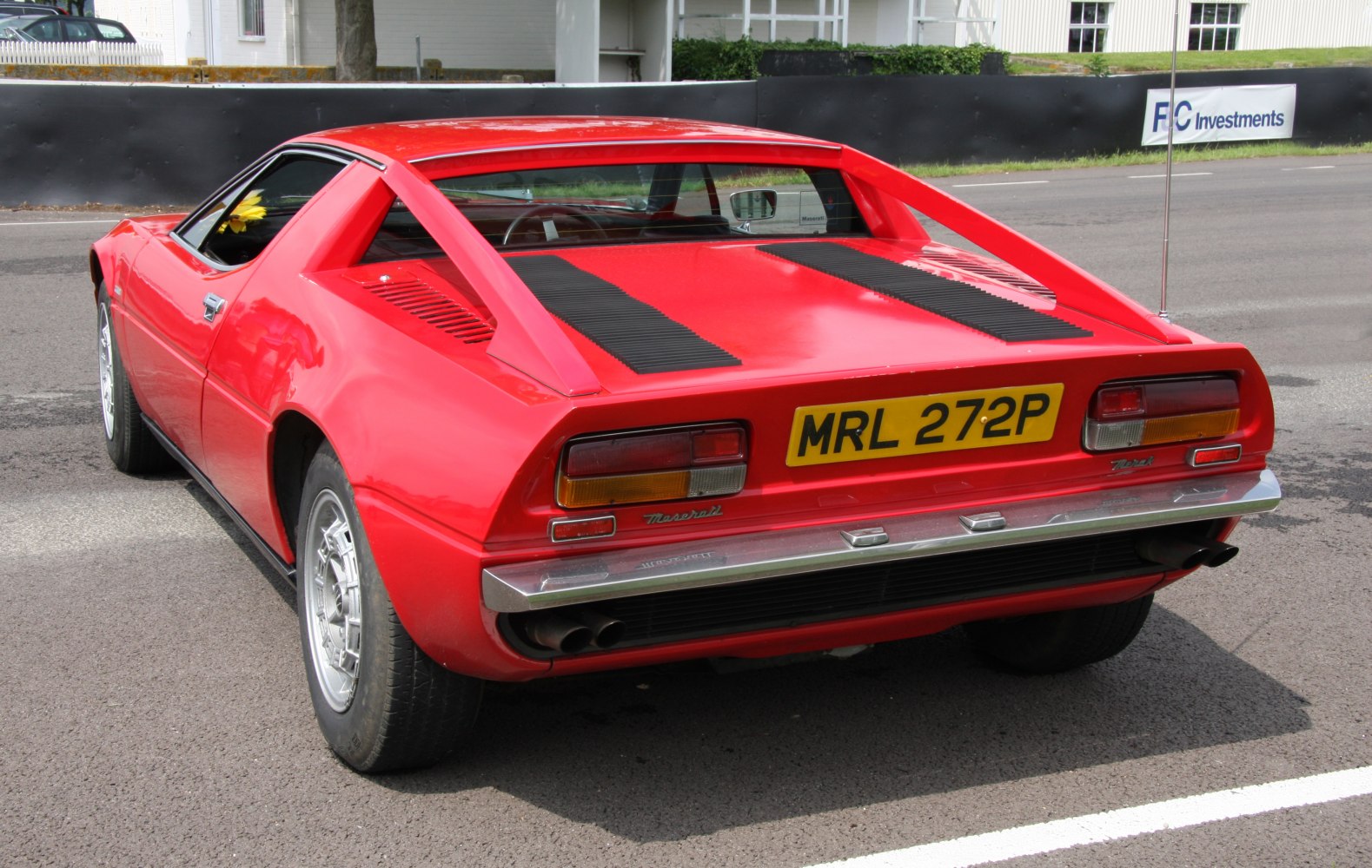 Rear view of vintage sports coupe with rear vents and dual exhaust
