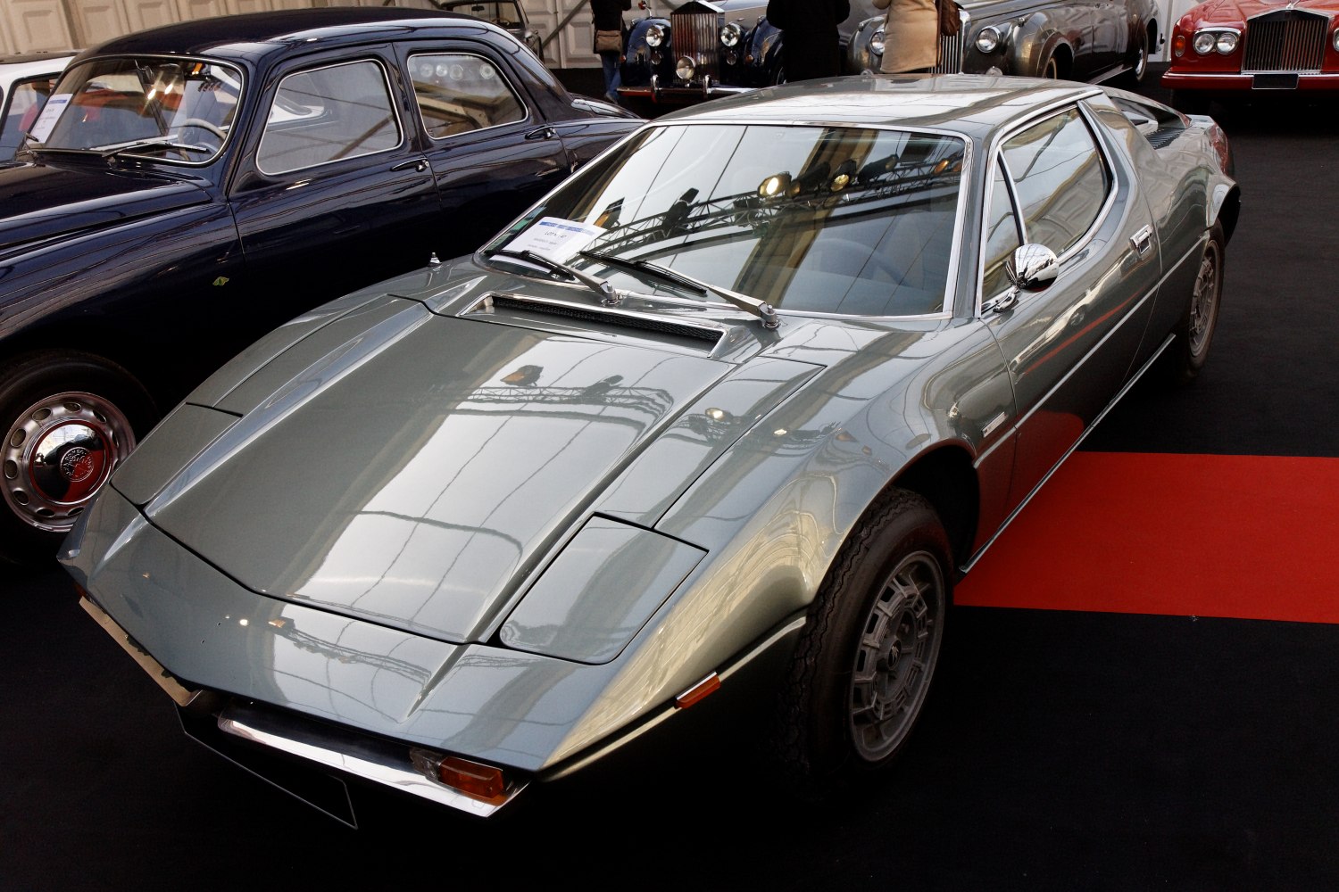 Sleek 1970s sports coupe with pop-up headlights and vented hood