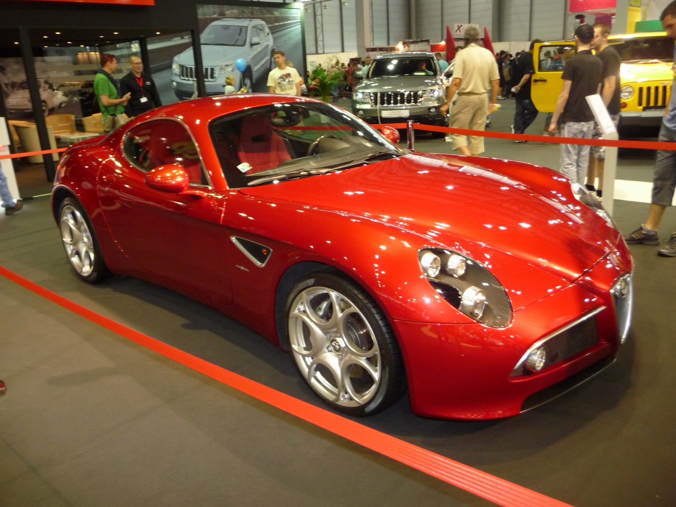 Sleek red sports coupe with distinctive quad headlights and sporty alloy wheels