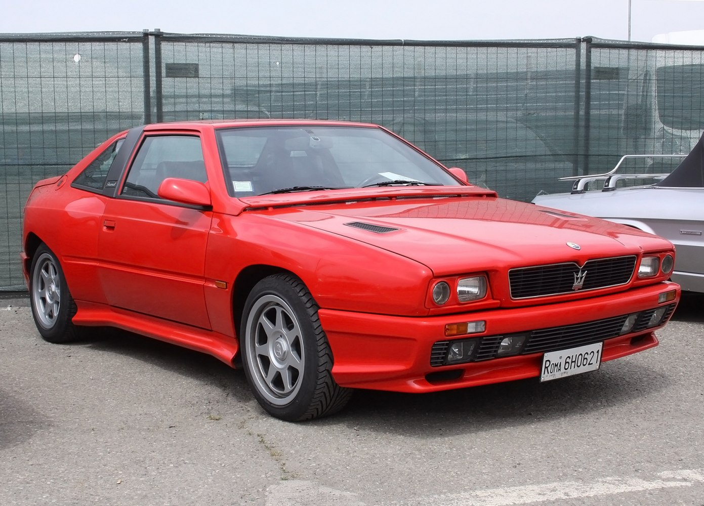 Front grille and side profile of a red two-door sports coupe