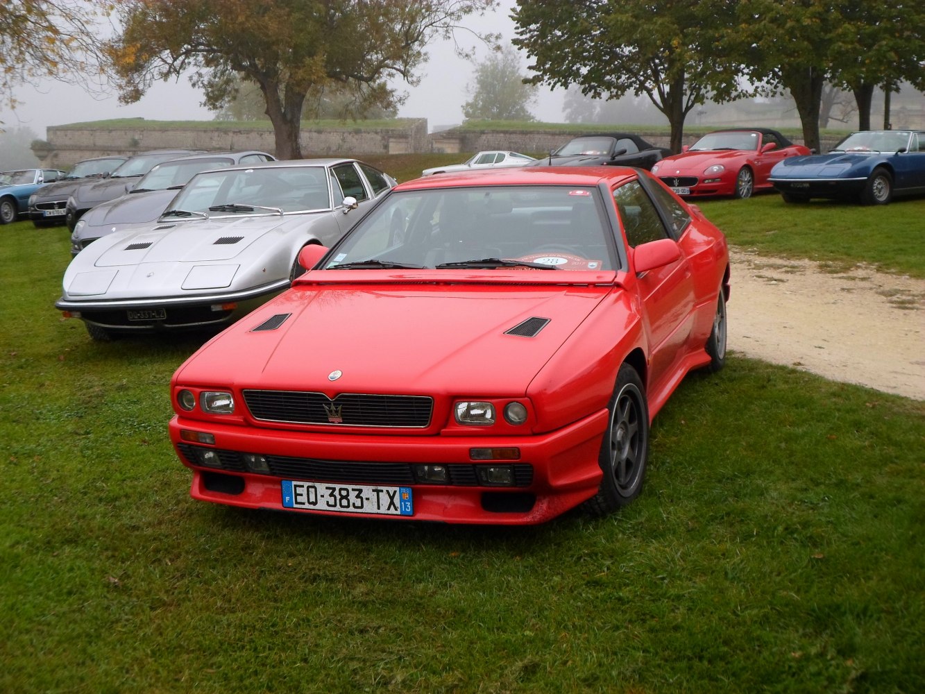 Front view of red sport coupe with dual headlamps and hood vents.