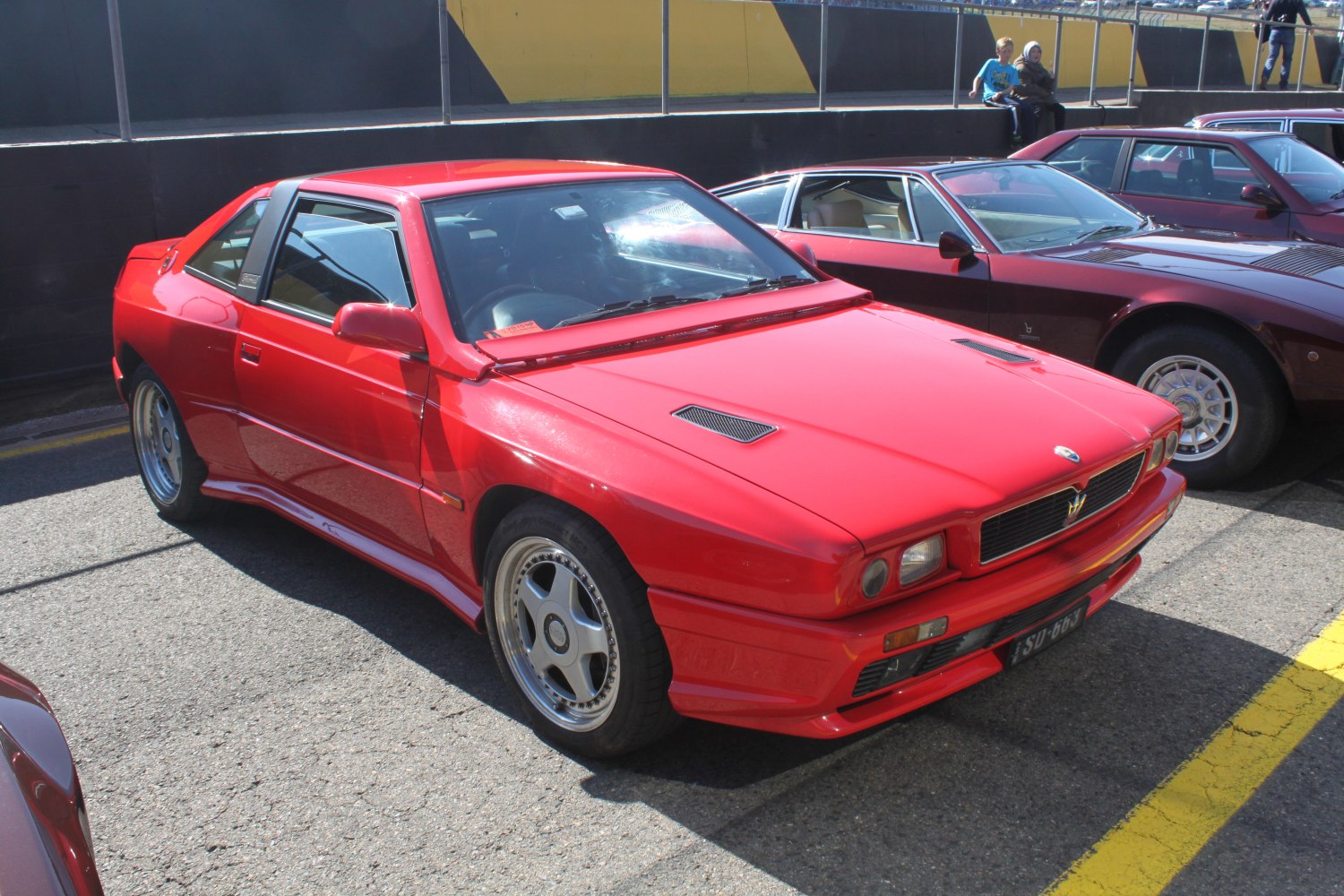 Red vintage sports coupe with hood vents and alloy wheels