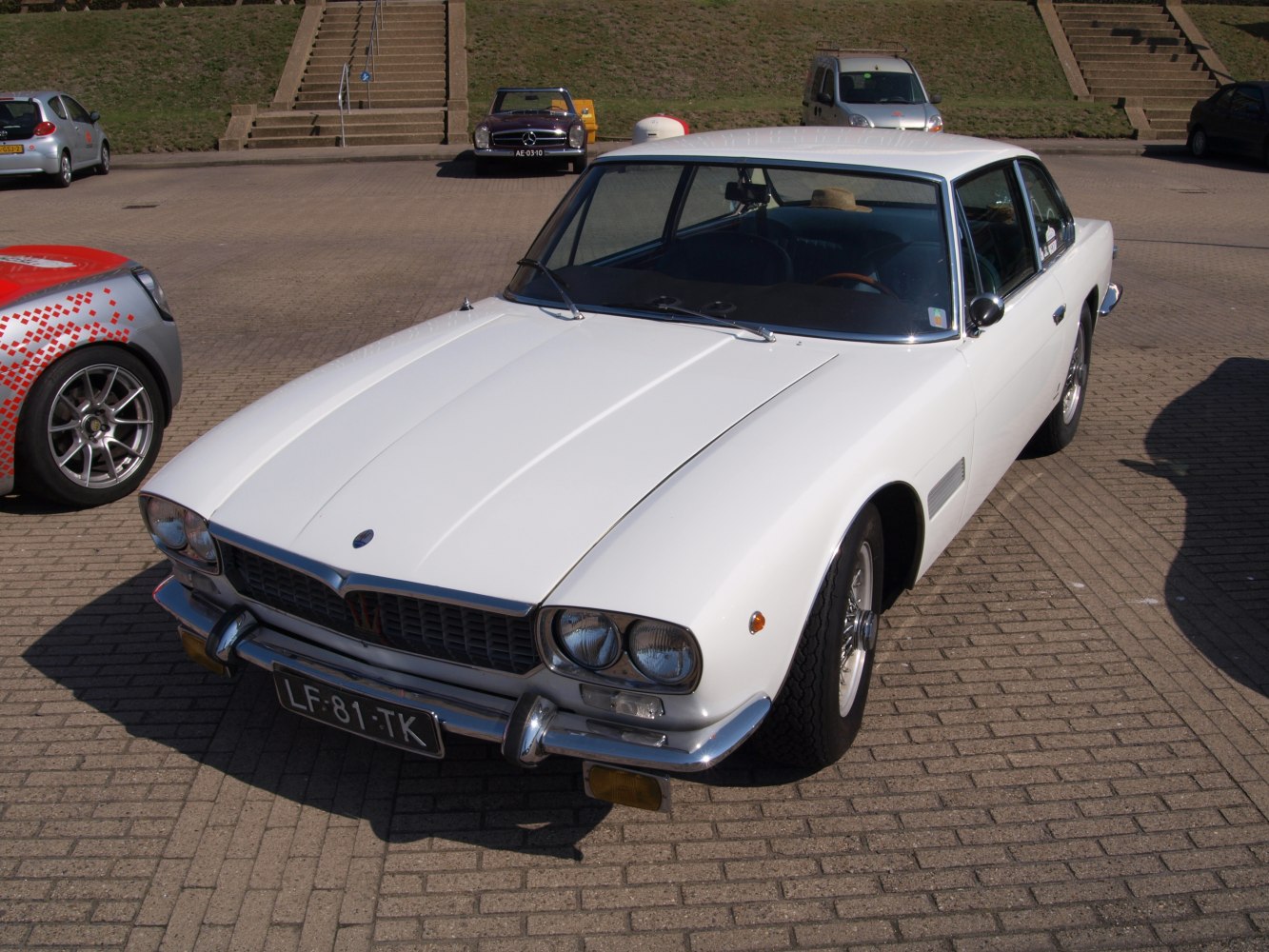 White classic coupe with dual headlights and chrome bumper