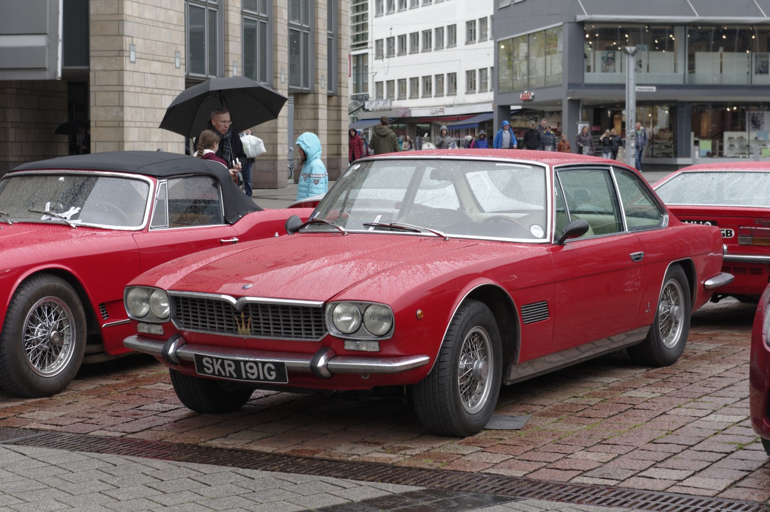 Red vintage sports coupe with wire spoke wheels and dual front headlights