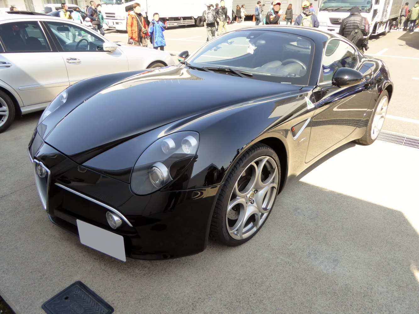 Sleek black sports car with distinctive circular alloy wheels and aerodynamic body.
