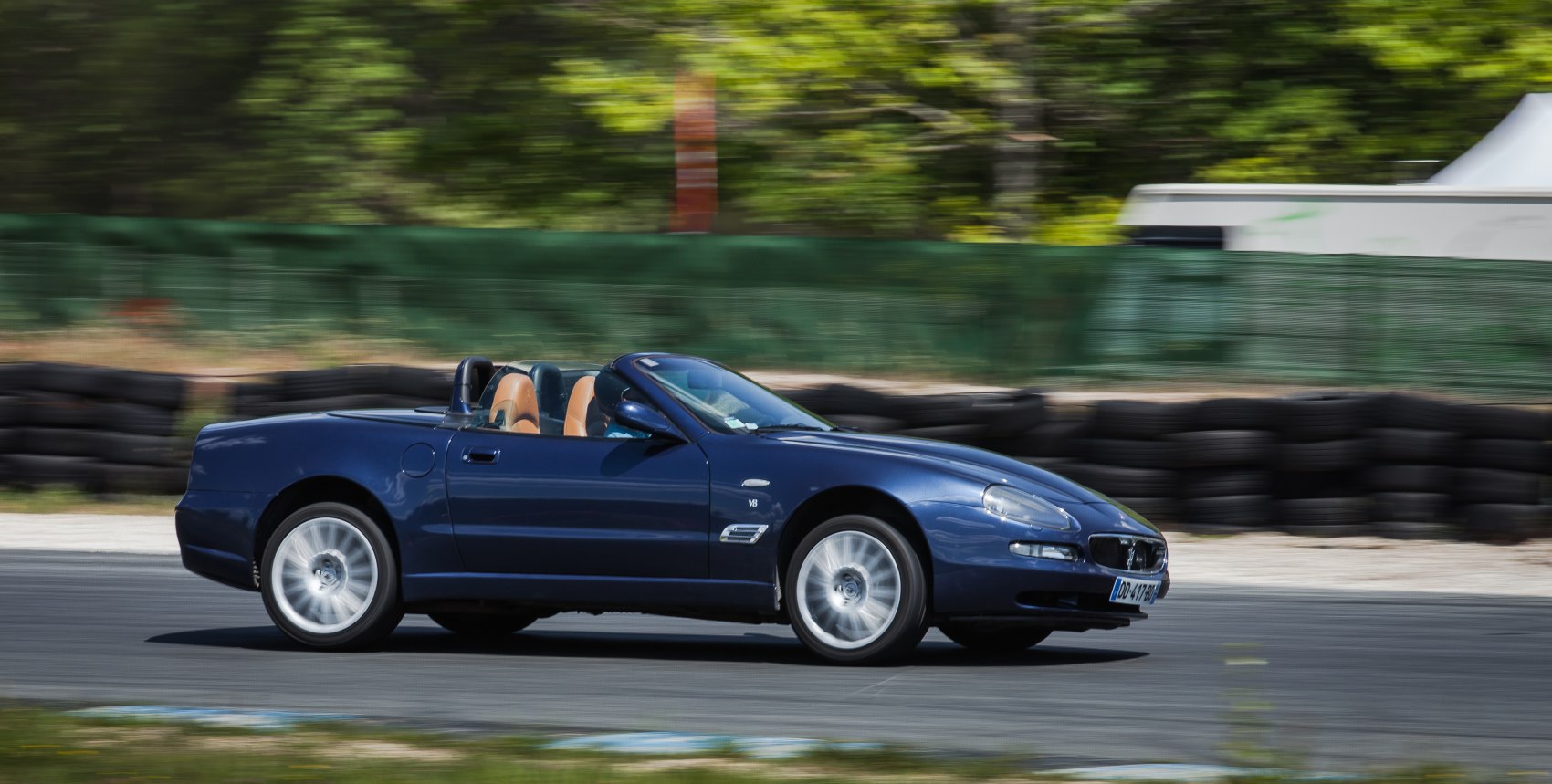 Convertible sports coupe with V8 engine and tan leather interior in motion