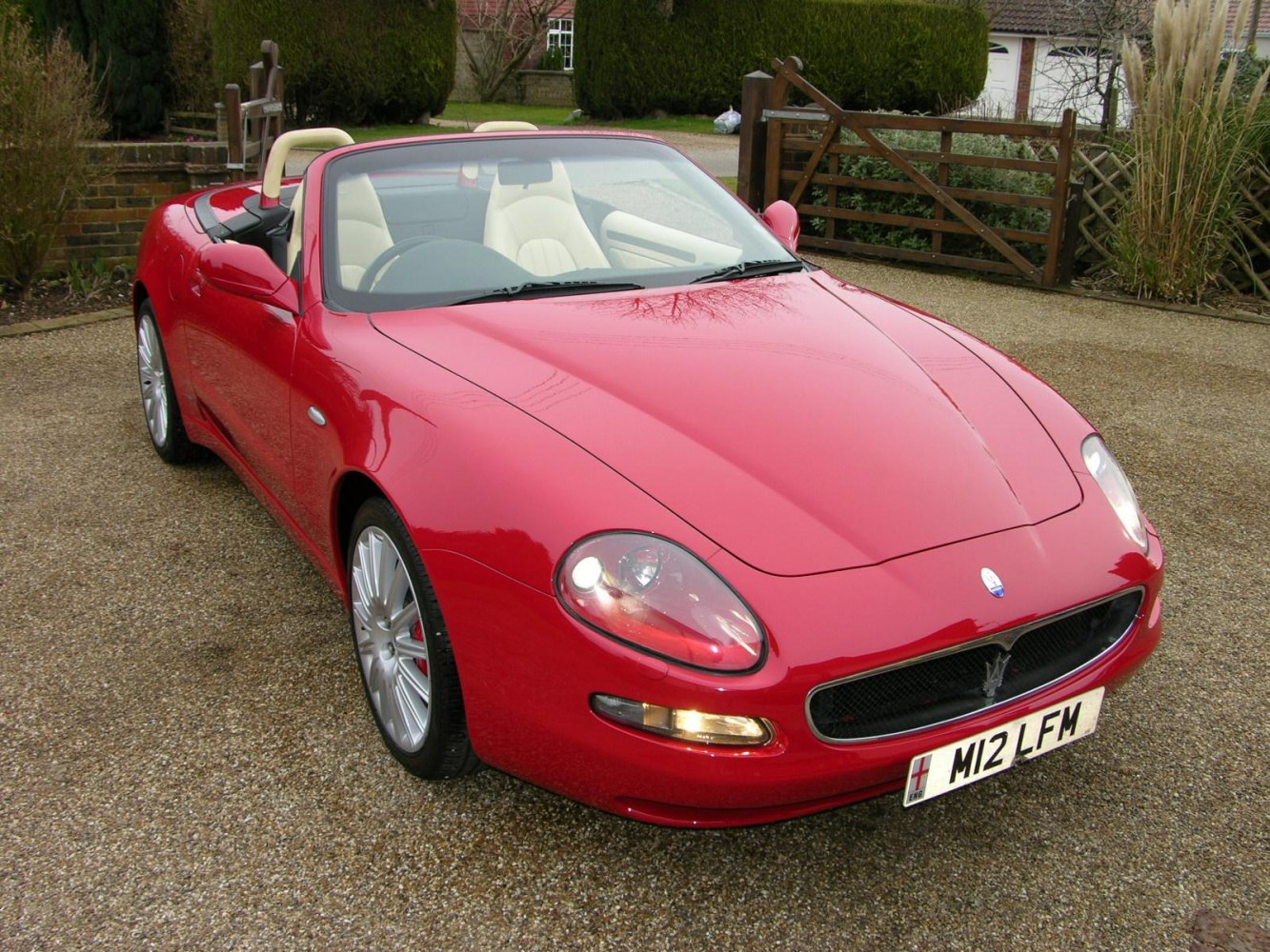 Red convertible sports roadster with light leather seats and sleek front design