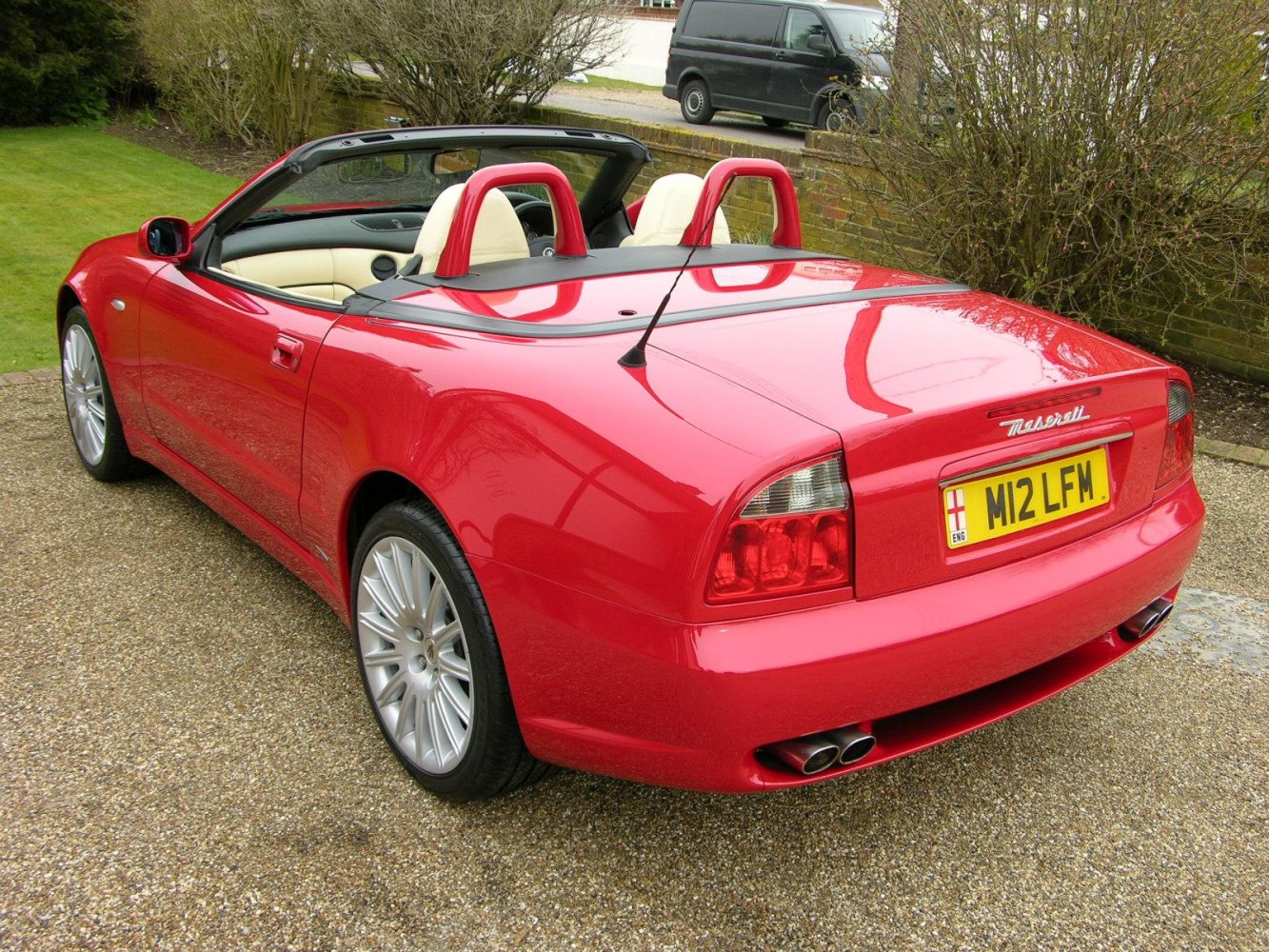 Red convertible rear view with dual exhaust and cream interior