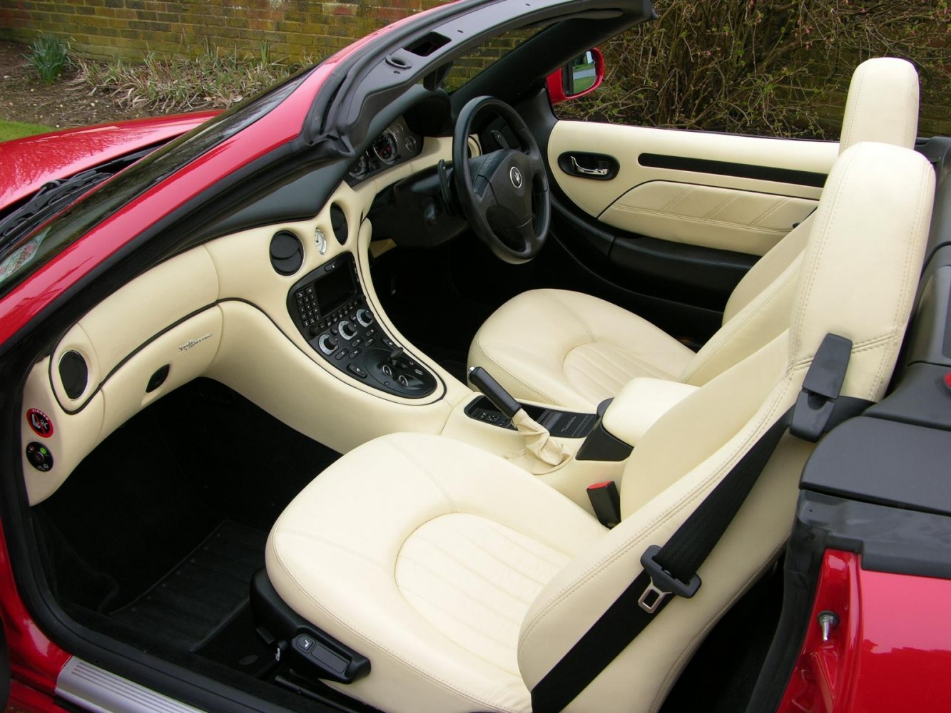 Cream leather seats and center console with control panel in convertible interior
