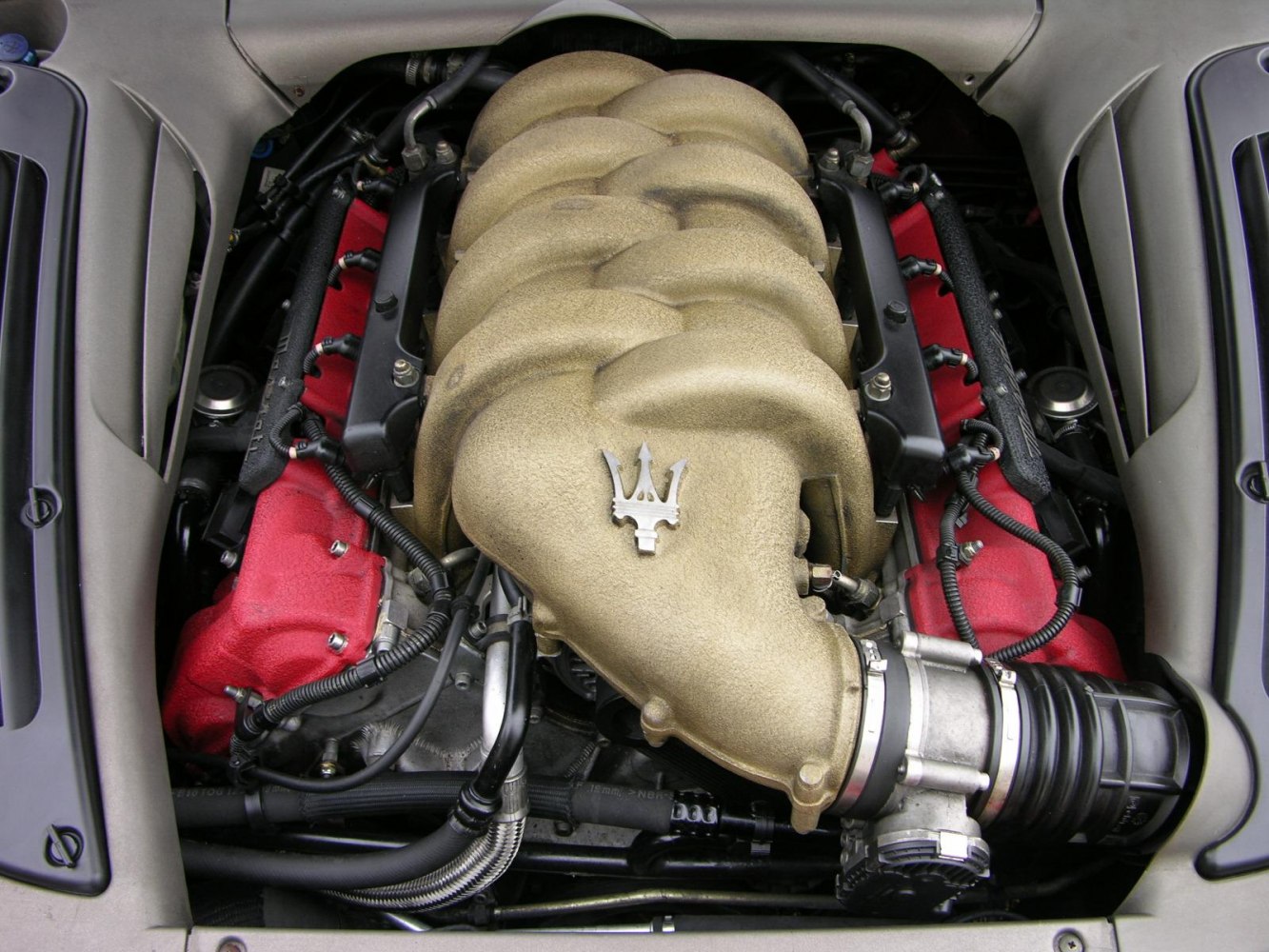 Distinctive engine intake manifold with trident emblem and red valve covers