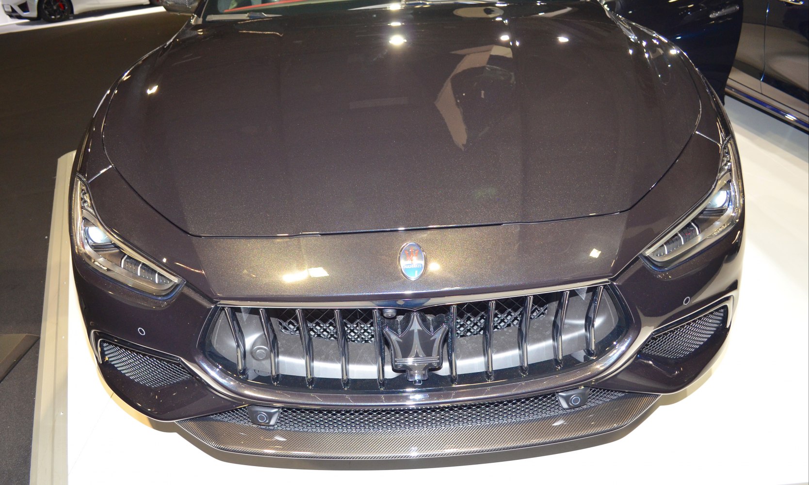 Close-up of sporty front grille and sleek headlights with trident emblem