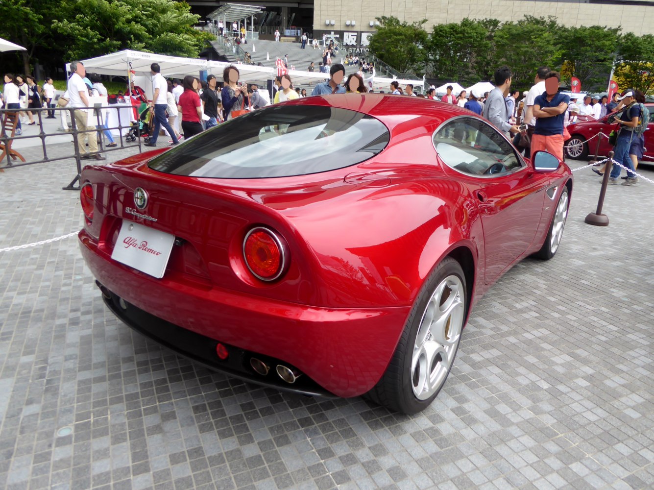 Sleek rear of a classic sports coupe with round taillights and quad exhausts