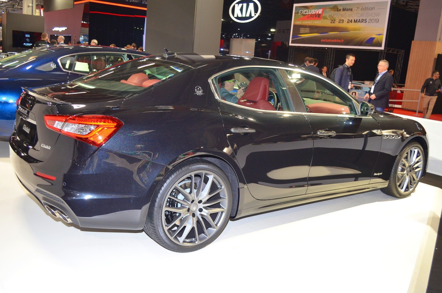 Luxury sport sedan rear side view with alloy wheels and red interior