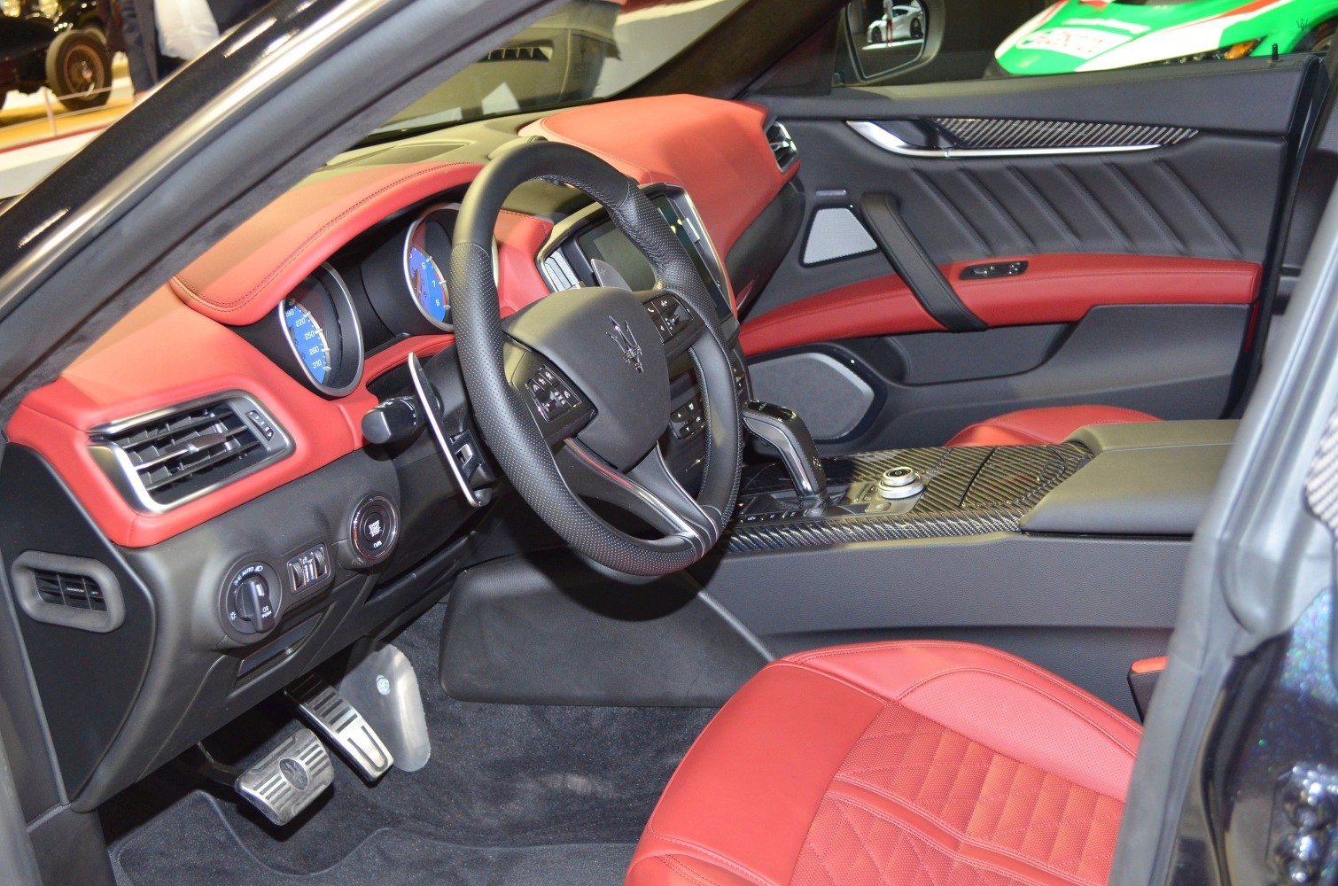 Red leather seats and carbon fiber trim in luxury sports sedan interior.
