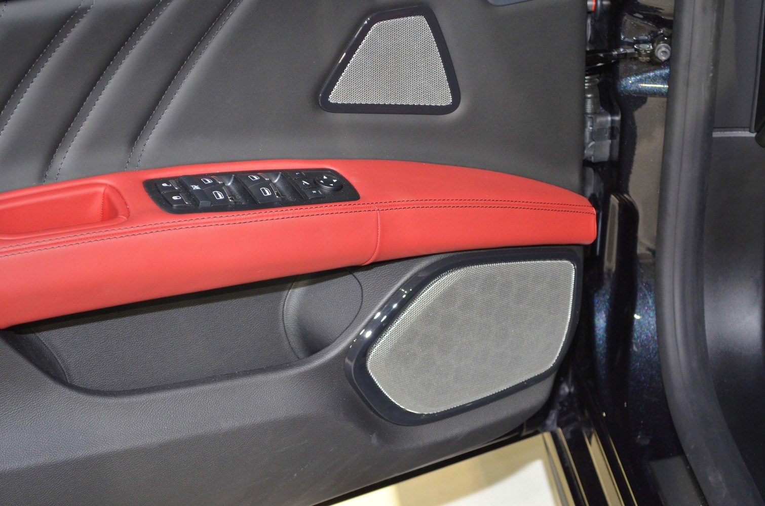 Interior door panel with red leather trim and control buttons