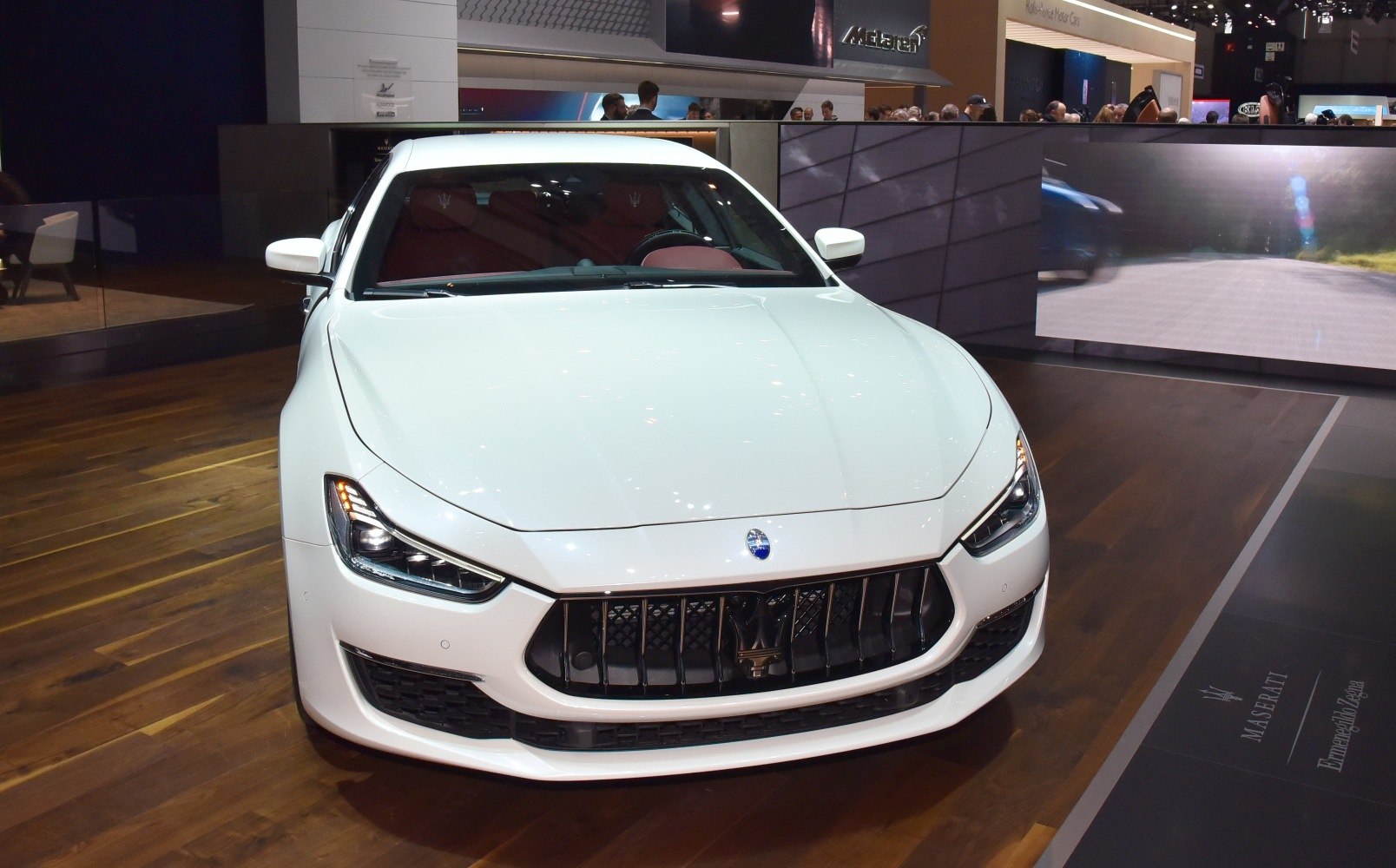 Aggressive front grille and sleek headlights of a white luxury sedan