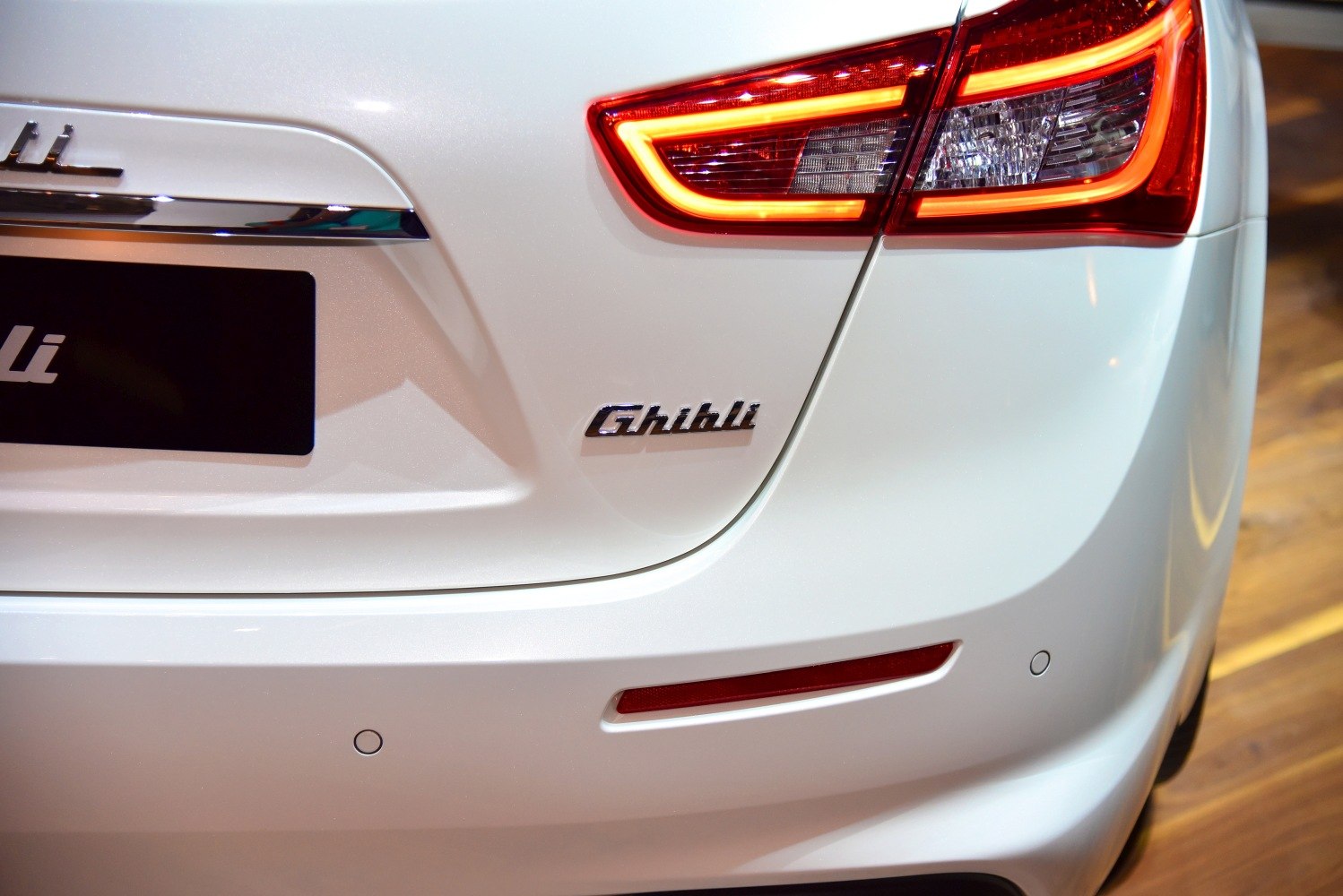 Close-up of LED rear tail light and Ghibli badge on white rear panel.
