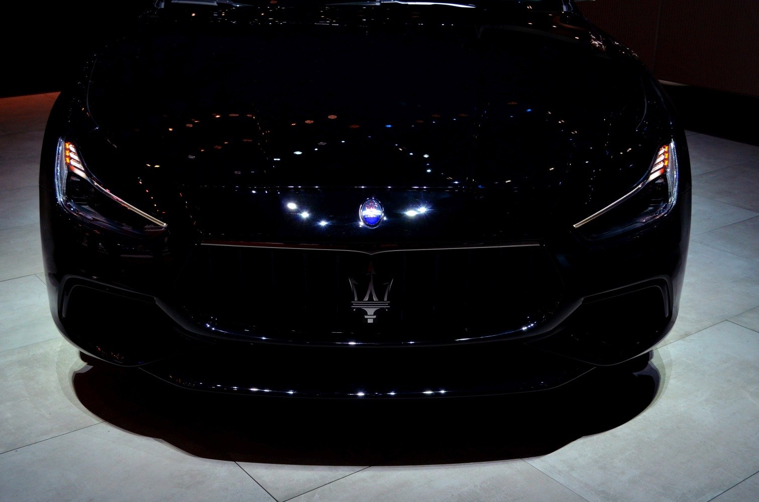 Close-up of front grille with trident emblem and sleek LED headlights