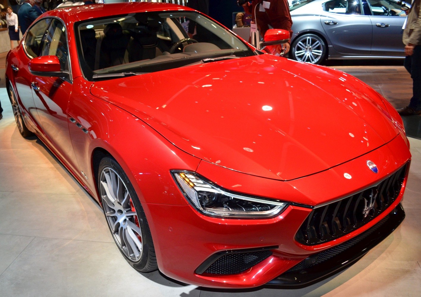 Luxury sedan front angled view with sharp LED headlights and prominent grille.