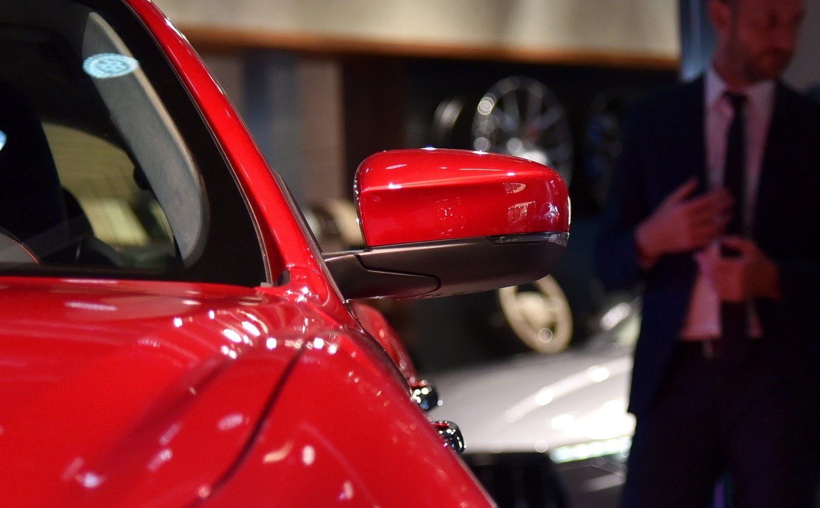 Close-up of a red side mirror with sleek design and integrated indicator.