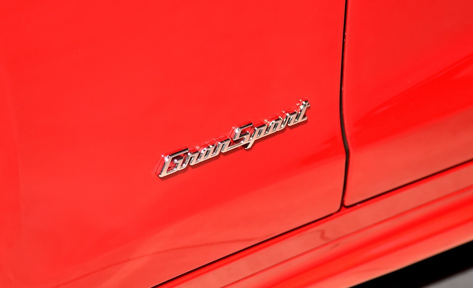 Close-up of GranSport emblem on a red car body panel