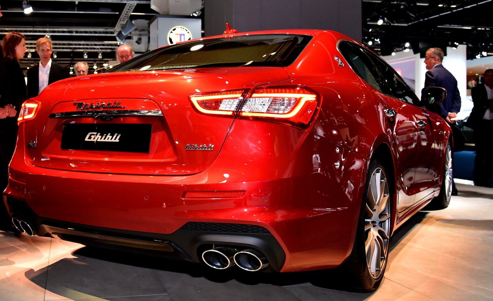 Rear view with LED taillights and quad exhaust tips on red sedan