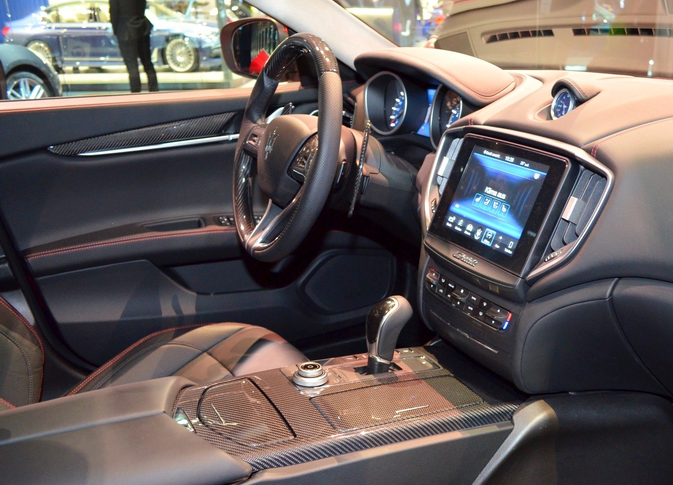 Luxury car interior with carbon fiber trim and touchscreen infotainment
