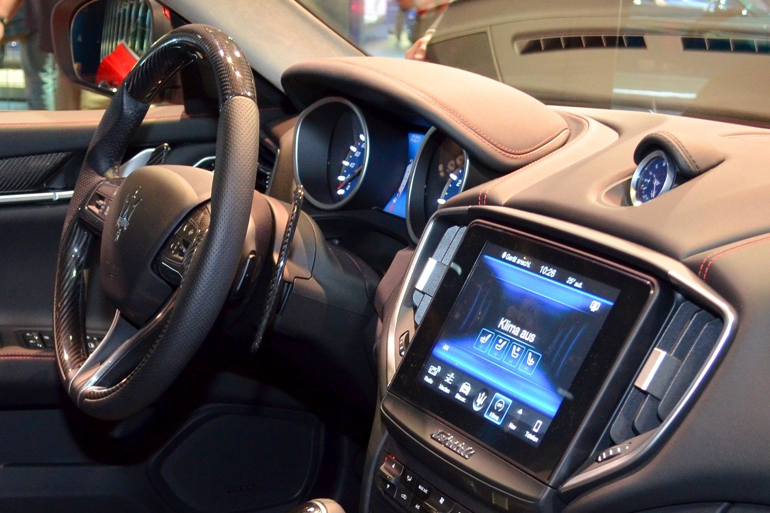 Luxury car interior with carbon fiber steering wheel and digital infotainment display