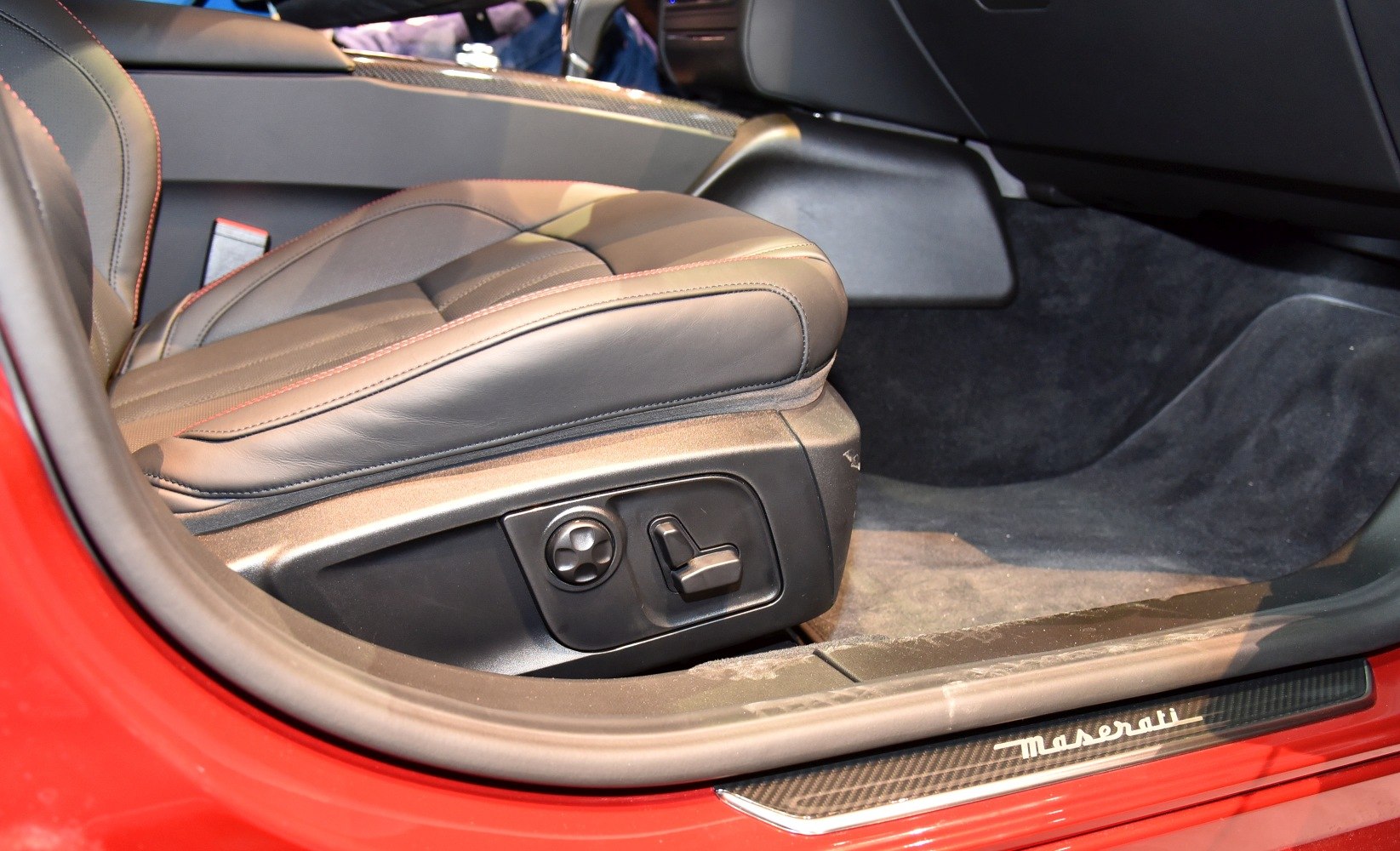 Electric seat controls and Maserati branded door sill in car interior