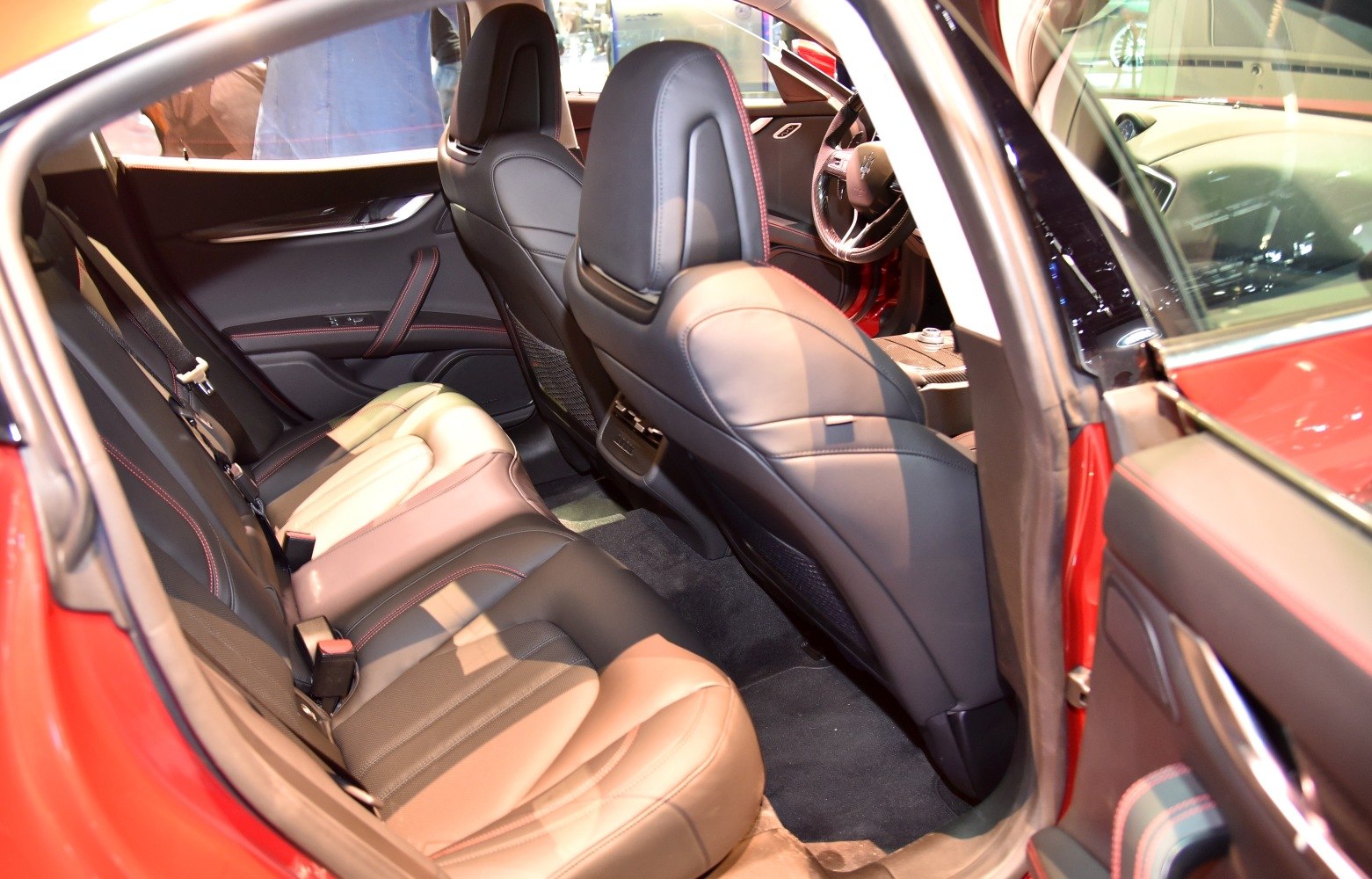 Leather rear seats with red stitching and spacious cabin interior.
