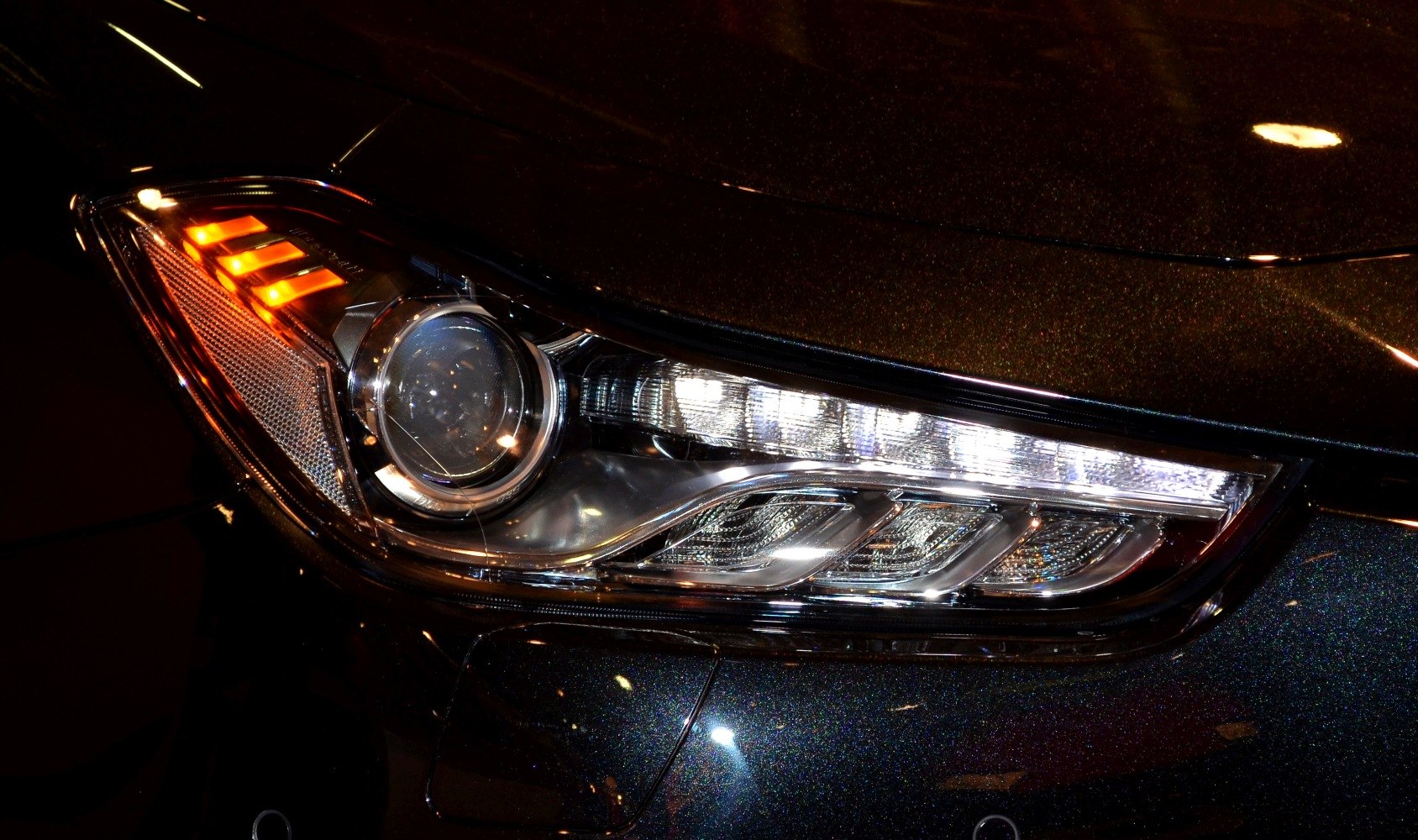 Close-up of a modern LED car headlight with orange indicator lights