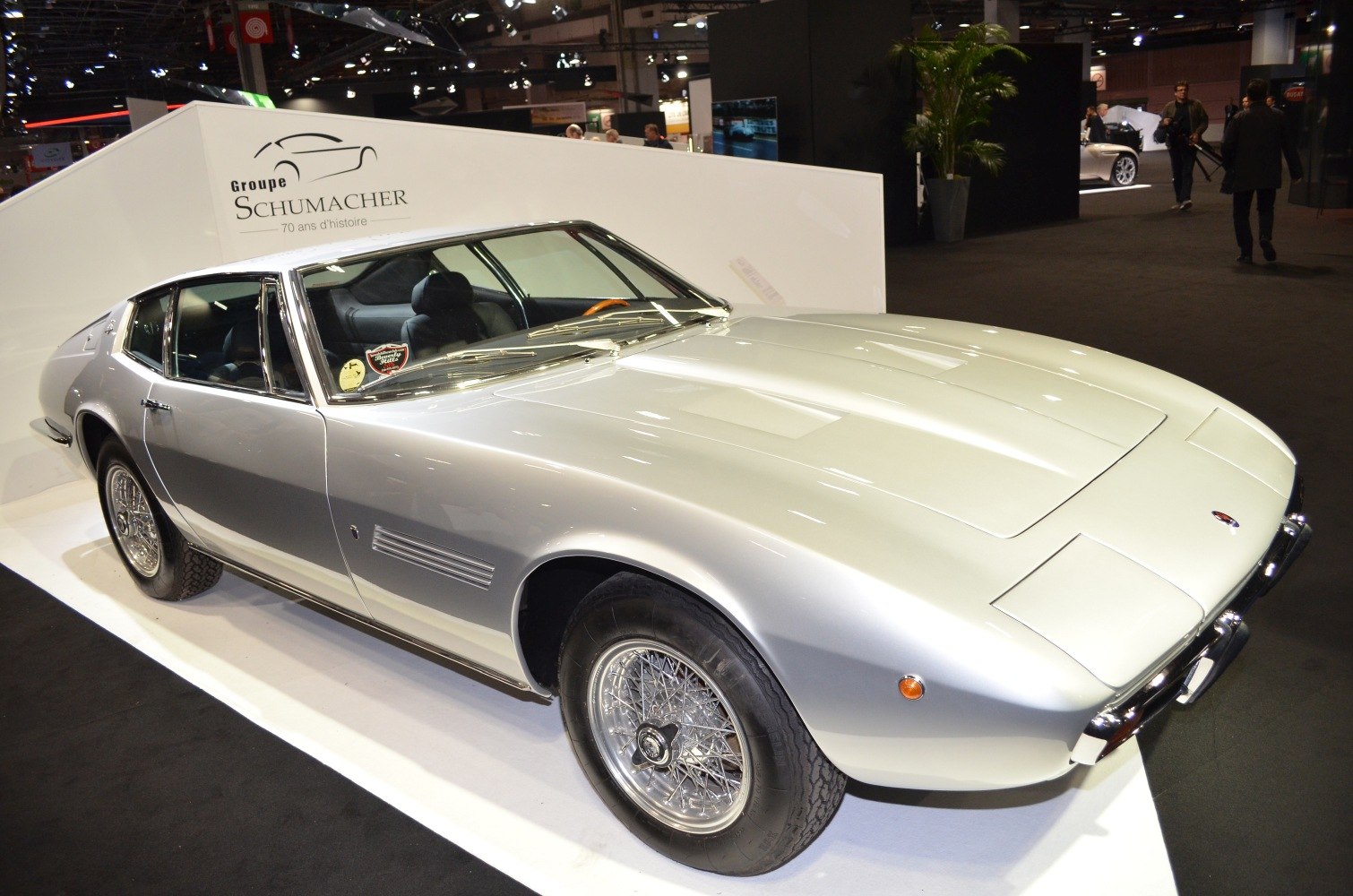 Silver vintage sports coupe with wire-spoke wheels and pop-up headlights