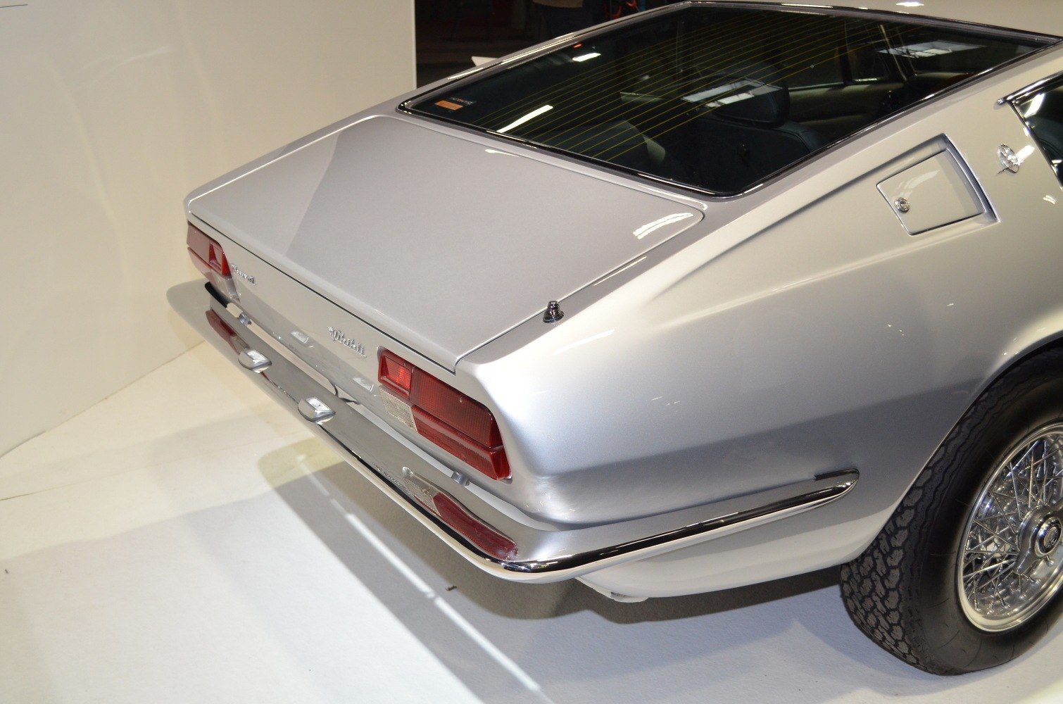 Vintage silver sports coupe rear end with wire-spoke wheels and classic taillights