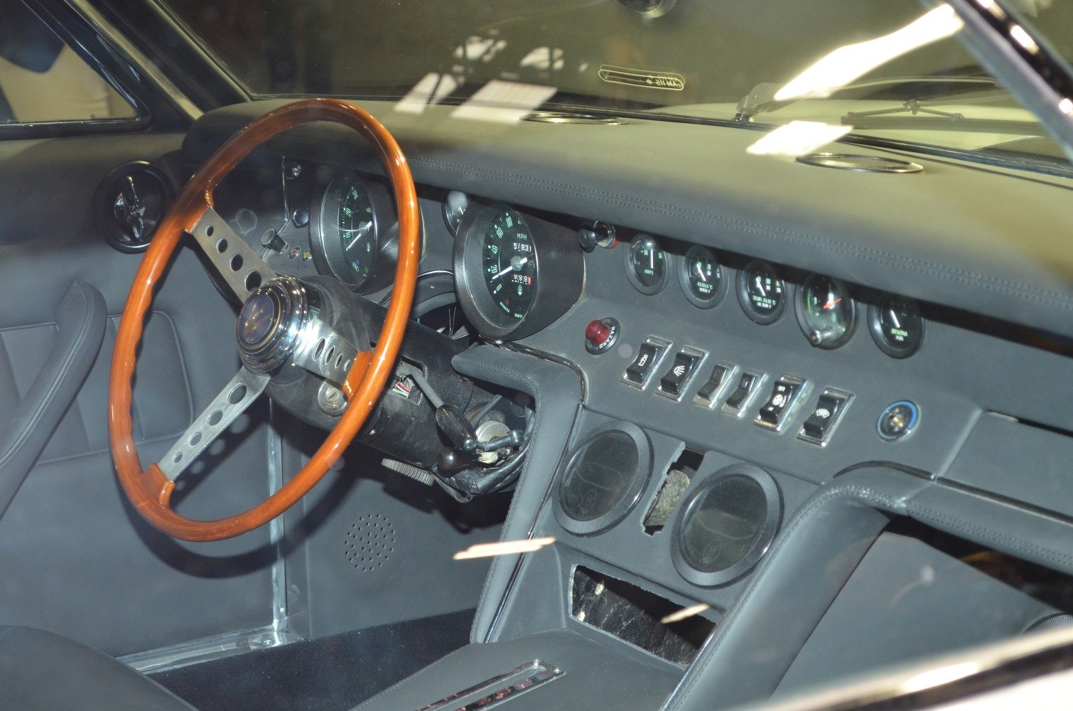 Wooden steering wheel with vintage analog gauges and dashboard switches